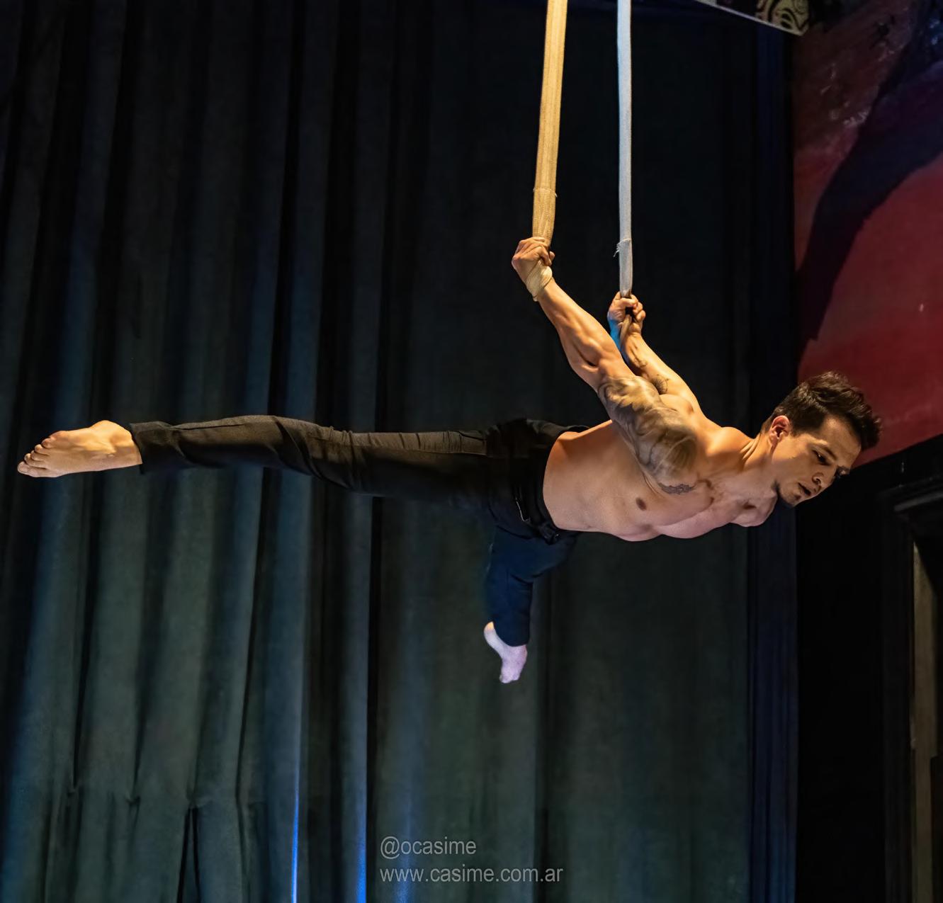 Artista realizando un número aéreo en straps